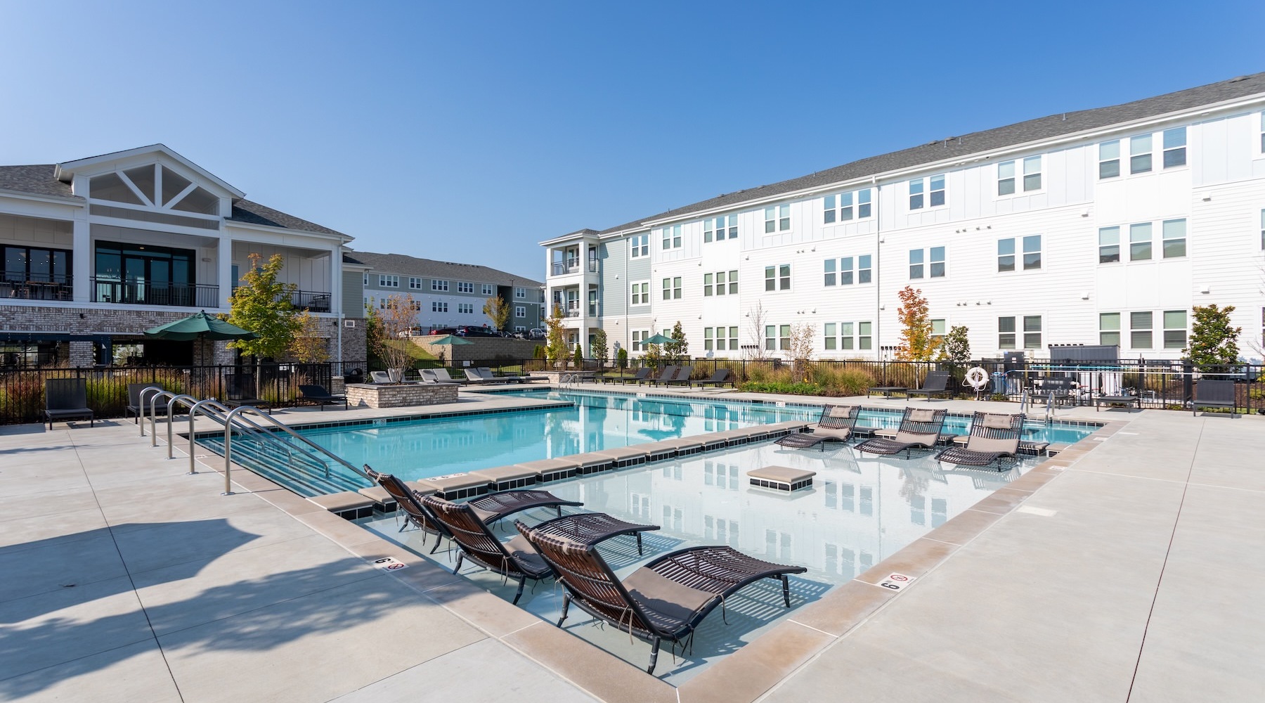 a courtyard with a pool and lounge chairs