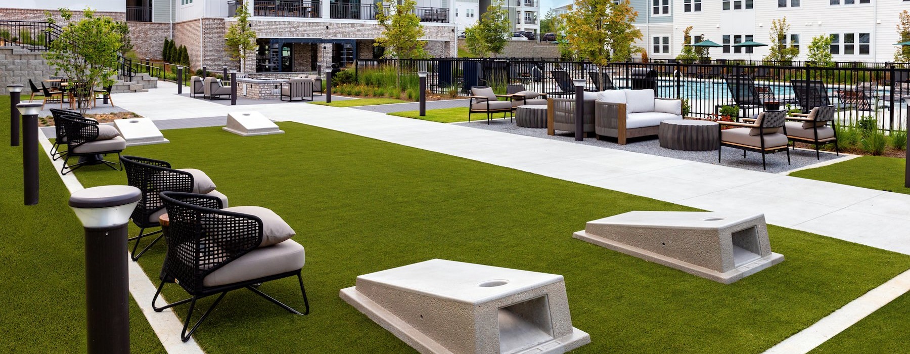 a courtyard with chairs and cornhole